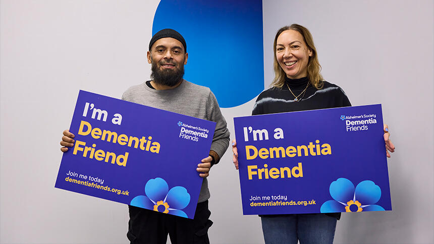 Two Dementia Friends Ambassadors holding up signs that say, 'I'm a Dementia Friend'