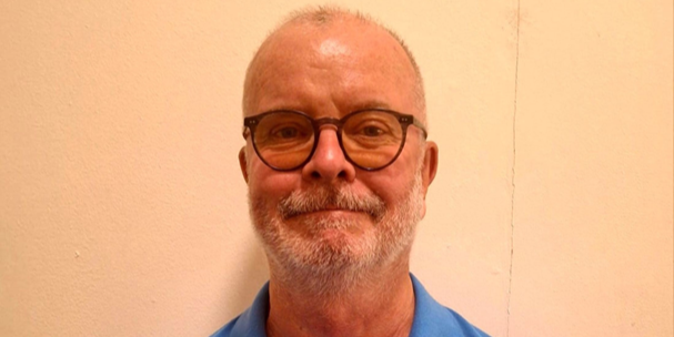 A smiling man wearing glasses