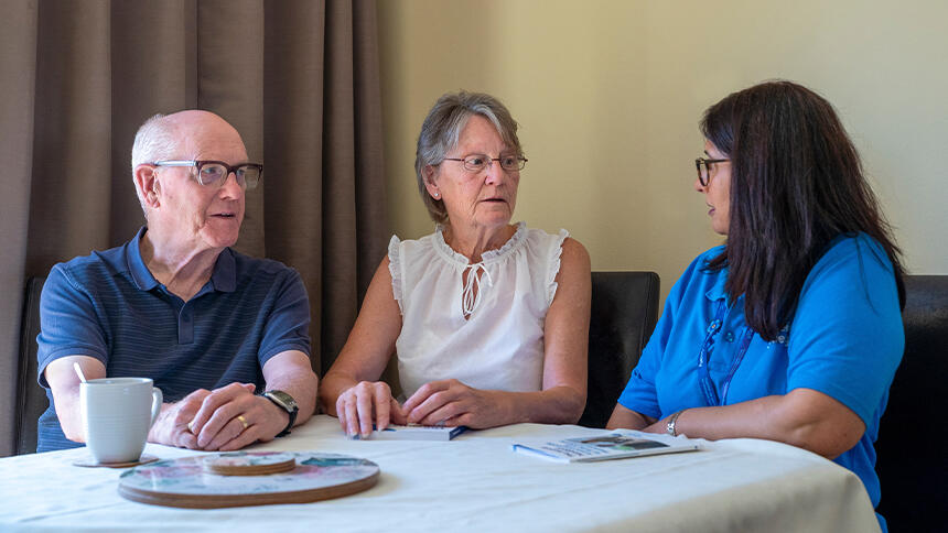 People talking to a dementia adviser with our publications