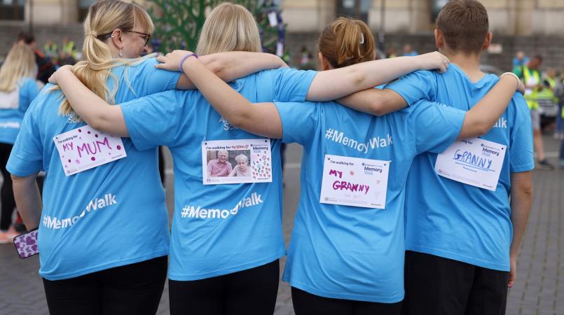 The backs of four Memory Walkers showing who they are walking for