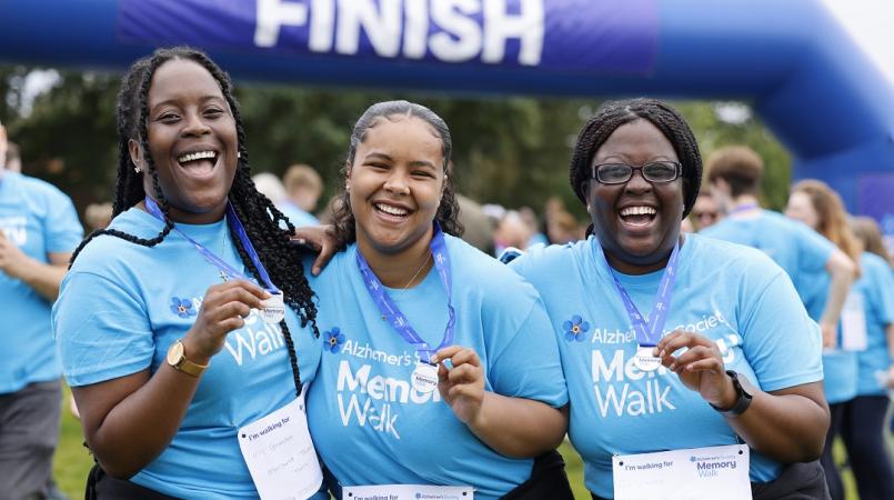 three supporters at the finish line with their medals