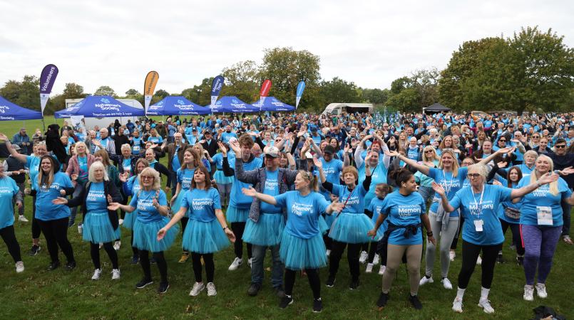 A group of Memory Walkers with their arms in the air as they take part in the Zumba warm up