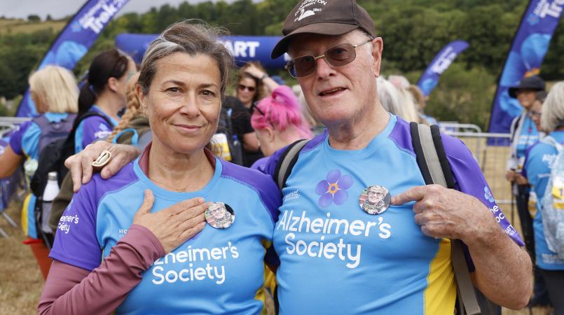 Man and woman pointing to a picture of a loved one on their top.