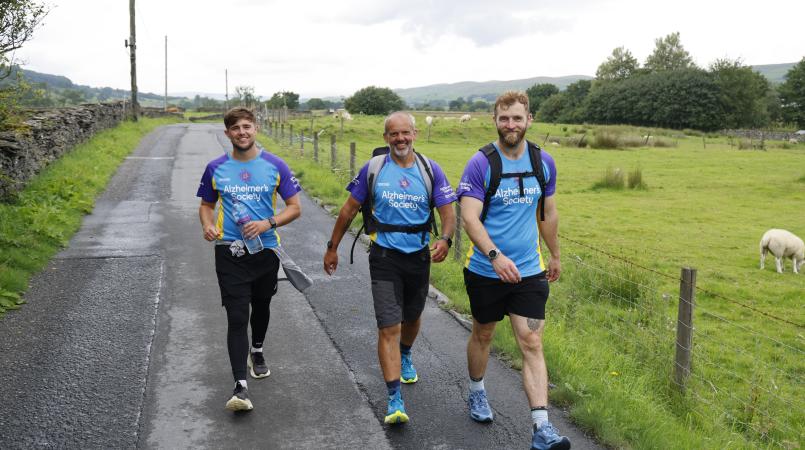 Three men walking down a country road.