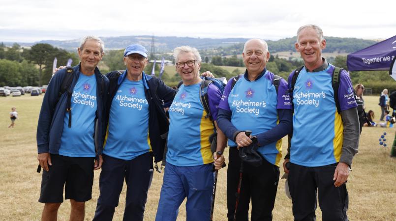 Group of men smiling with trekking tops on.