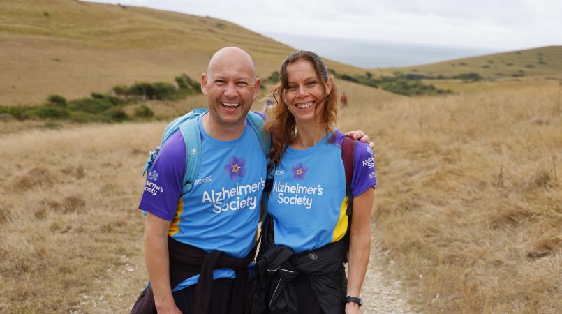 Couple smiling with rolling hills in the background.