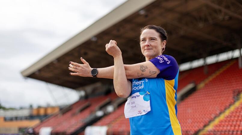 Woman outside at a stadium training for the Dementia Run Club