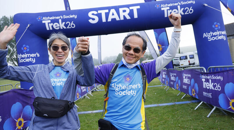 Man and woman posing in front of the Trek26 start line