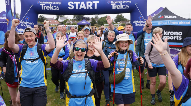 A group of people cheering at a trek26 start line.